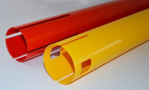 Rotes und gelbes Kunststoffrohr mit gefrästen Schlitzen